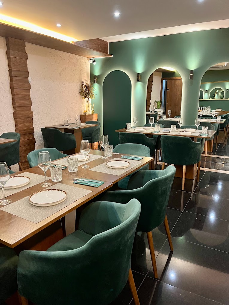 Fotografia da sala do Restaurante Minerva com espelhos em arco e cadeiras verdes